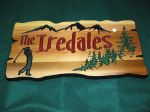 Wood sign with golfer mountains and trees